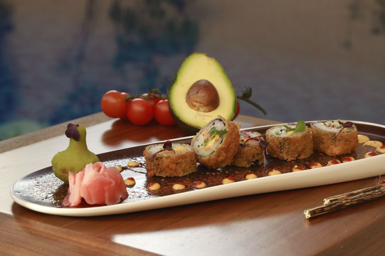 Home Indulge in mouth-watering crispy sushi rolls featuring avocado and pickled ginger.