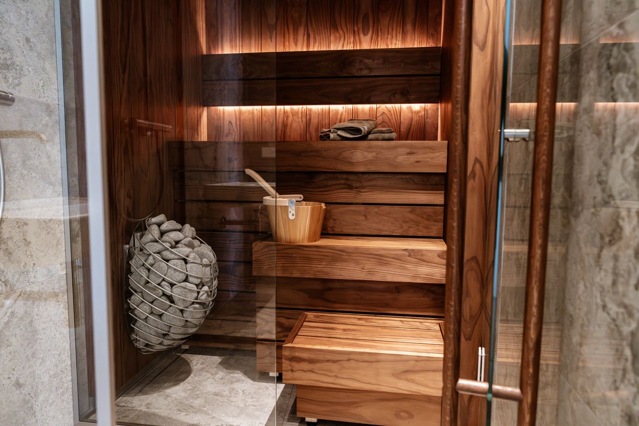 Discover the elegance of a modern indoor sauna featuring sleek wood panels and a glass door.